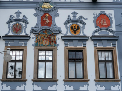An der Fassade vom Budweiser Rathaus befinden sich das Stadtwappen, das Wappen von Schlesien und Mhren