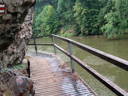 Wandelgang fhrt unter berhngenden Felsen am Fluss entlang. Trotz starkem Regen waren wir geschtzt