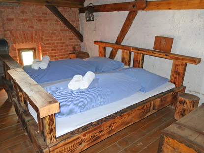 Blick in das Hotelzimmer. Der Raum wird durch Kerzen erhellt.