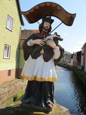 Die Statue des Heiligen Johannes von Nepumuk steht auf einer Brcke ber der Mud in Amorbach