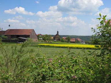 Blick vom Biergarten der Pension zum Brandweiher auf den Ort Beuchen