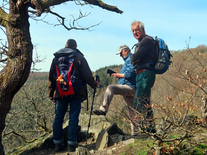 Drei Wandrer rasten am Saurierfelsen bei Espenschied